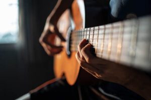 person plays guitar in music therapy